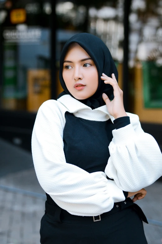 an asian woman wearing a black hat and white shirt