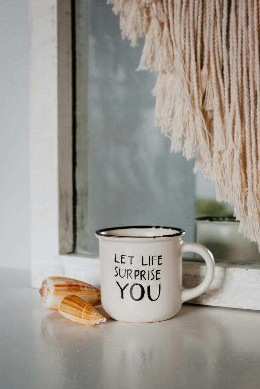 a cup on the table with some tassels