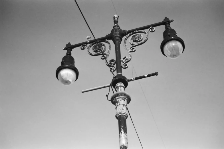 a black and white po of street lights against the sky