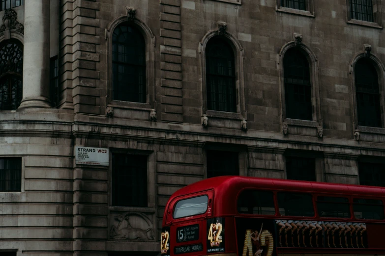 a red bus parked outside a large building