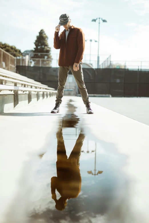 a man with a hat and glasses standing in the rain