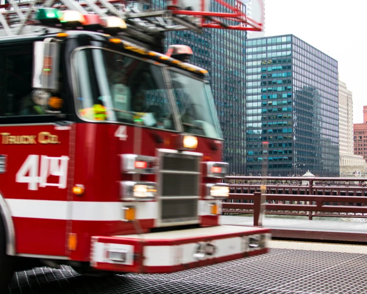 a fire truck on a city street with buildings in the background