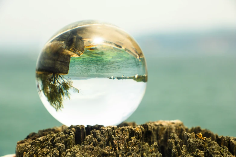 a large glass ball on top of a wooden stump