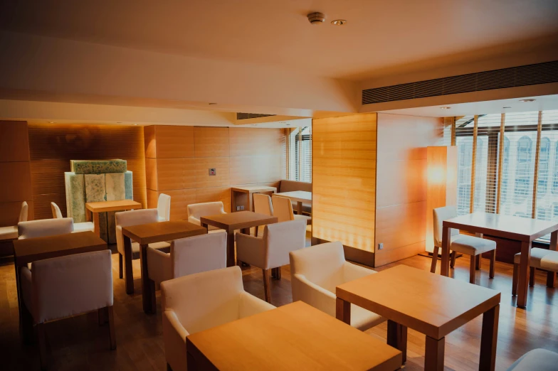 a large empty conference room with wooden tables and white chairs