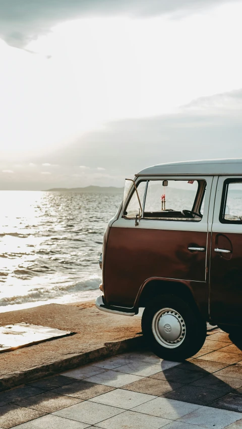 an old van is parked along the beach