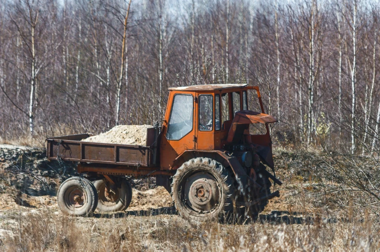 an old abandoned tractor standing out in a forest