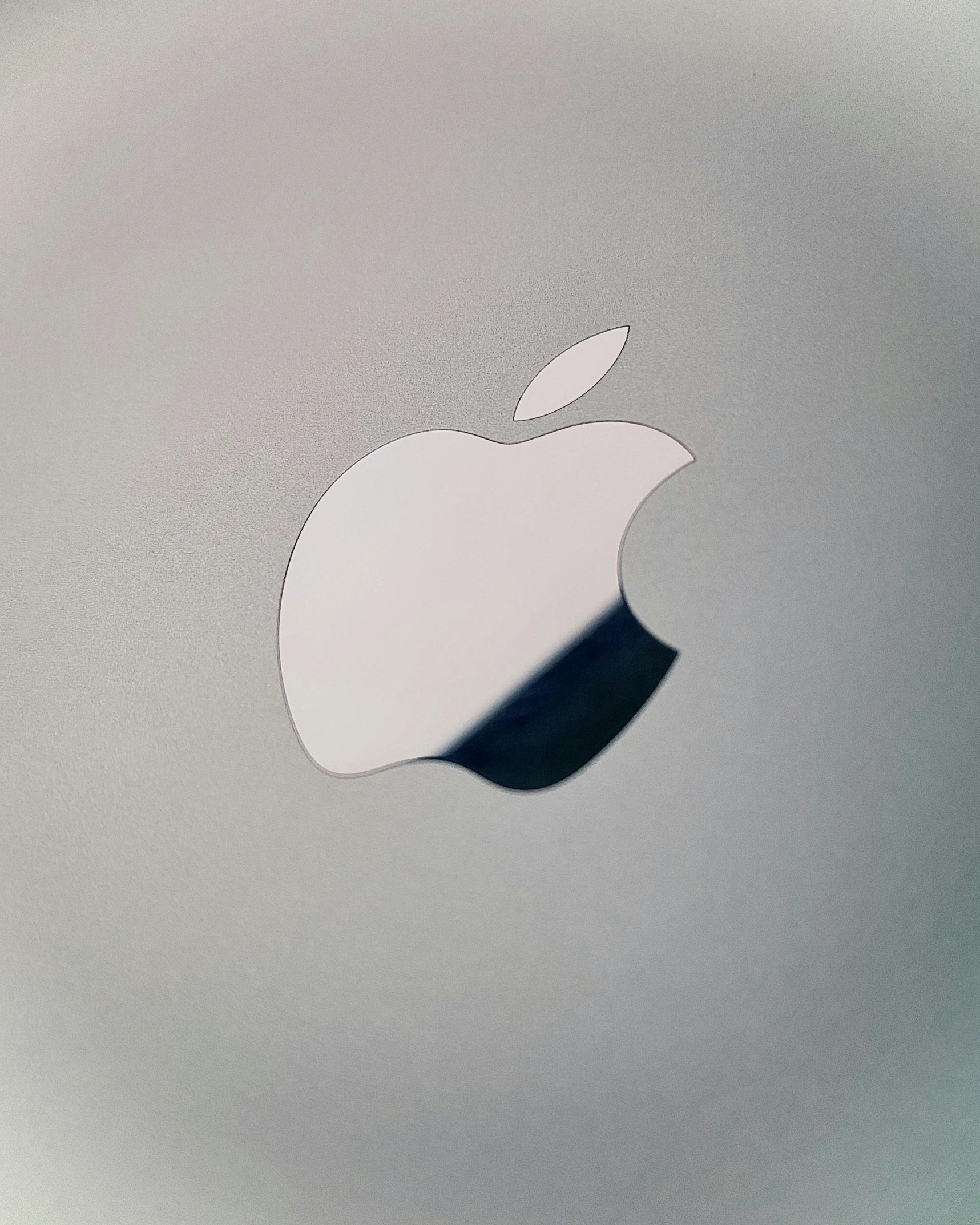 a silver apple logo on a clear and slightly reflective background