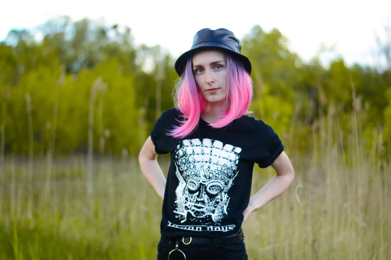 a woman with pink hair is wearing a skull tee