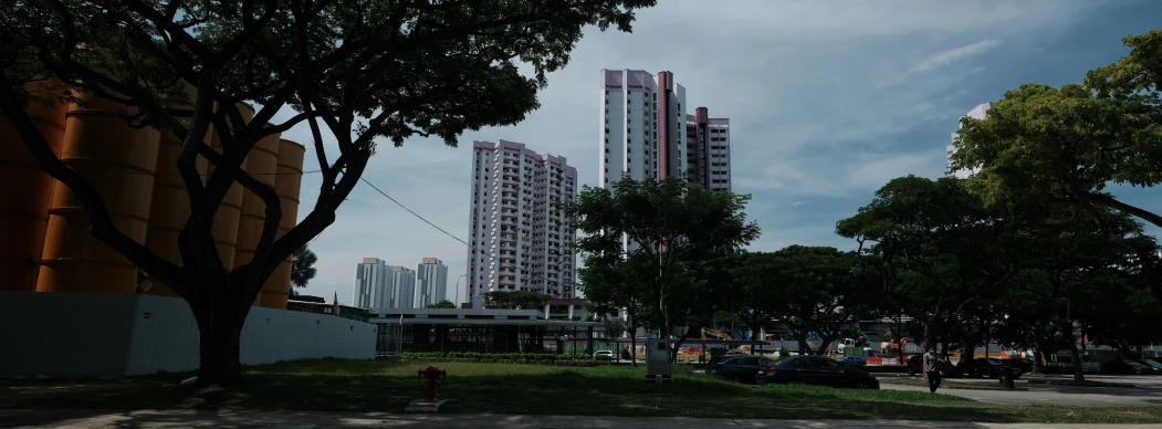 a street view of two high rise buildings and cars parked on the side