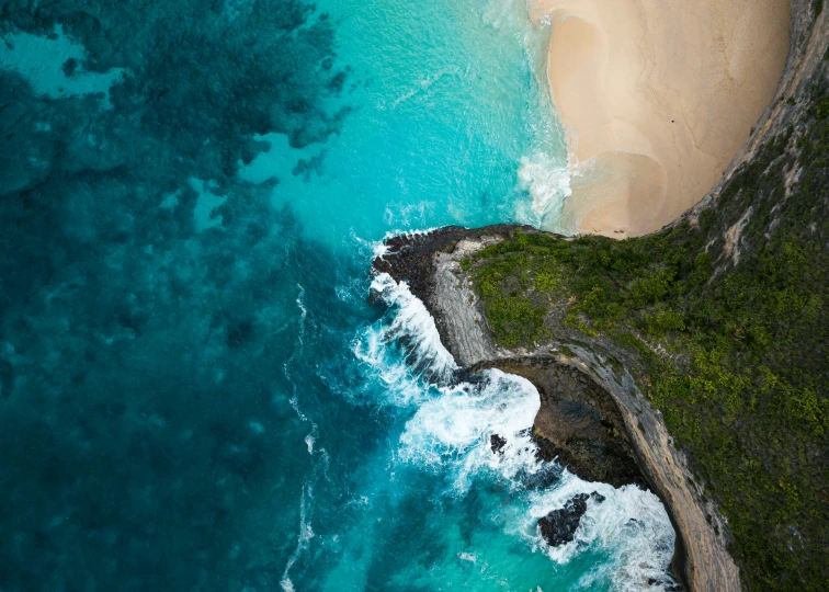 an aerial view of a sandy beach with a rocky coast