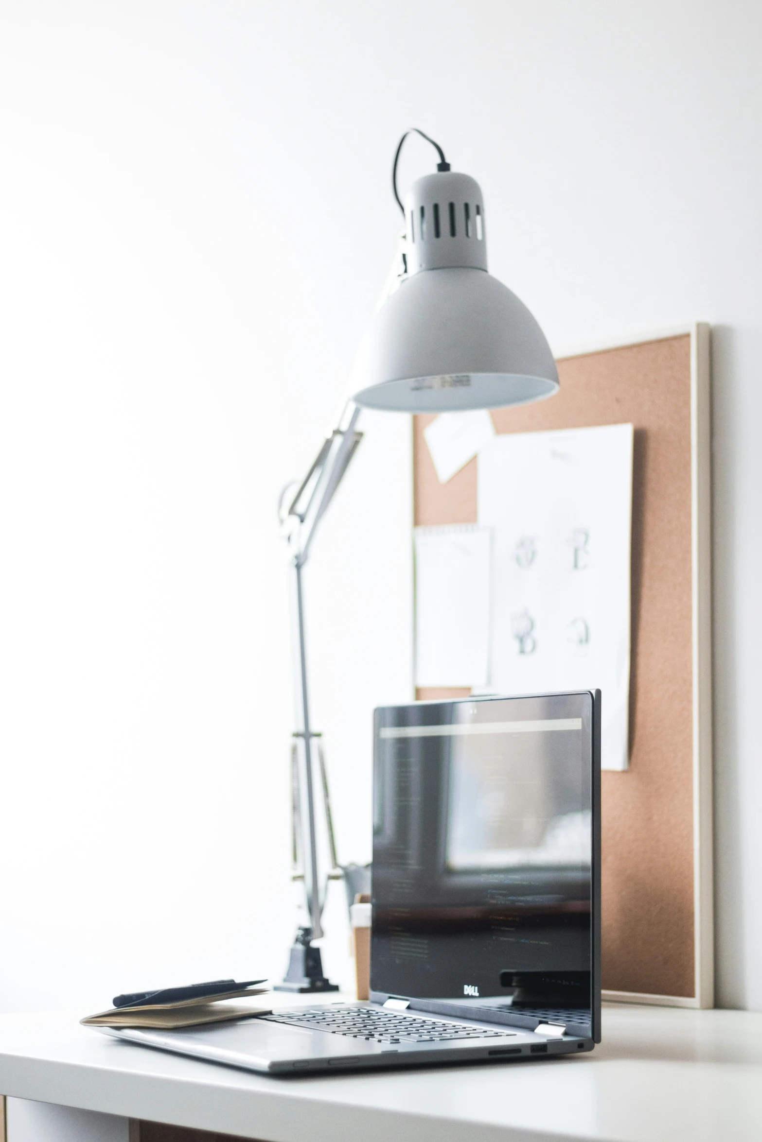 the light is on on a desk next to the laptop