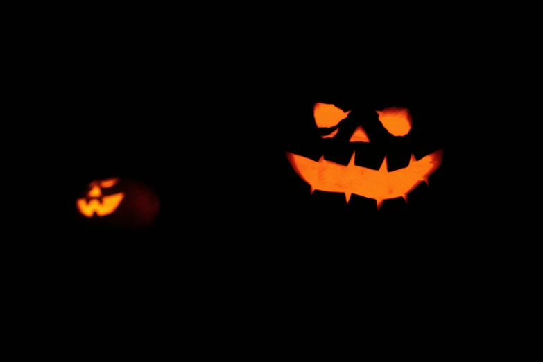 jack o lanterns lit up on dark night sky