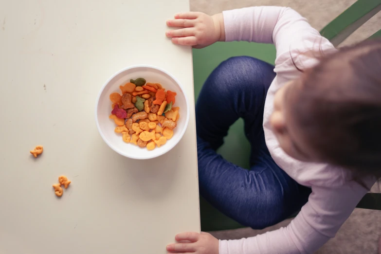 a  is looking down at a bowl full of food