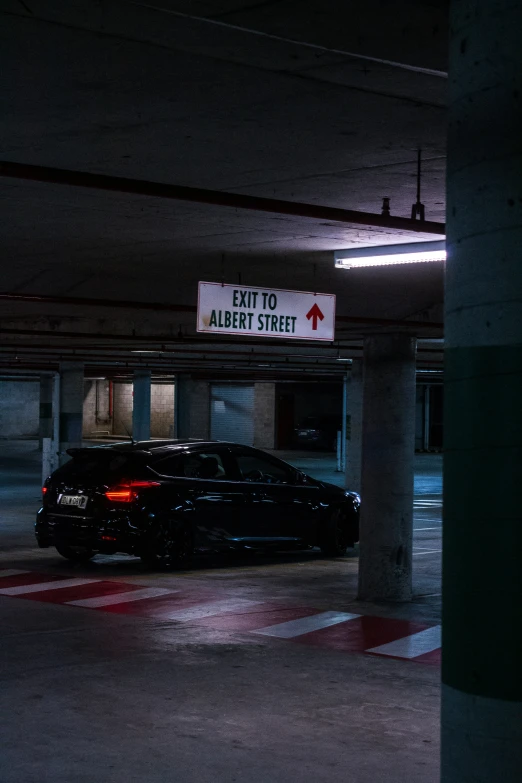 car parked in parking garage with sign that reads, hit to area quiet