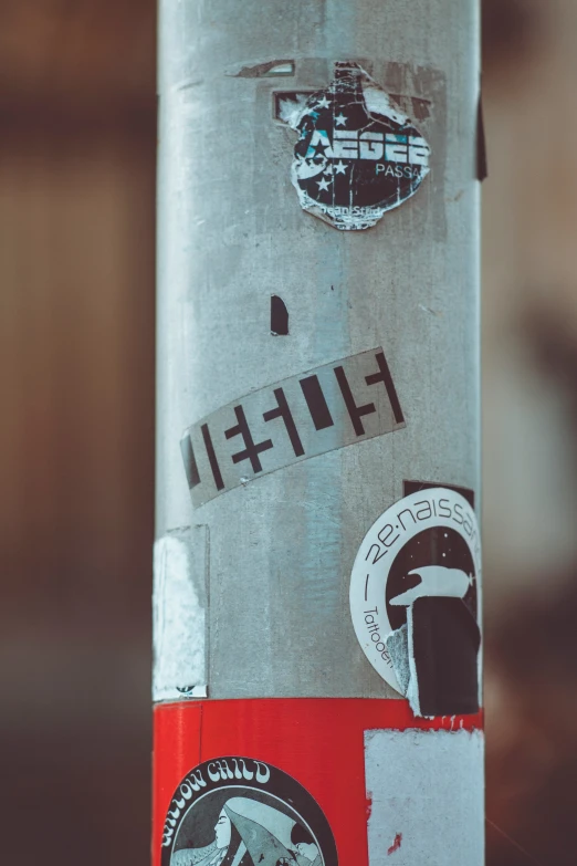 some different stickers and stickers on a metal pole