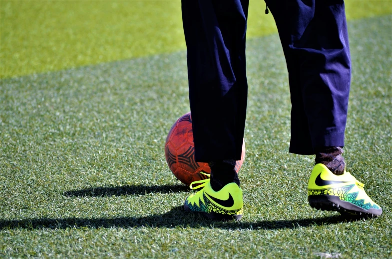 a man stands in grass playing with a soccer ball