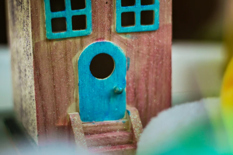 a toy dollhouse with a blue door and window