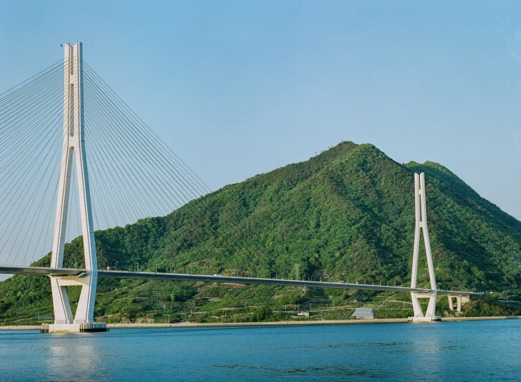 the bridge in the ocean on a hill next to water