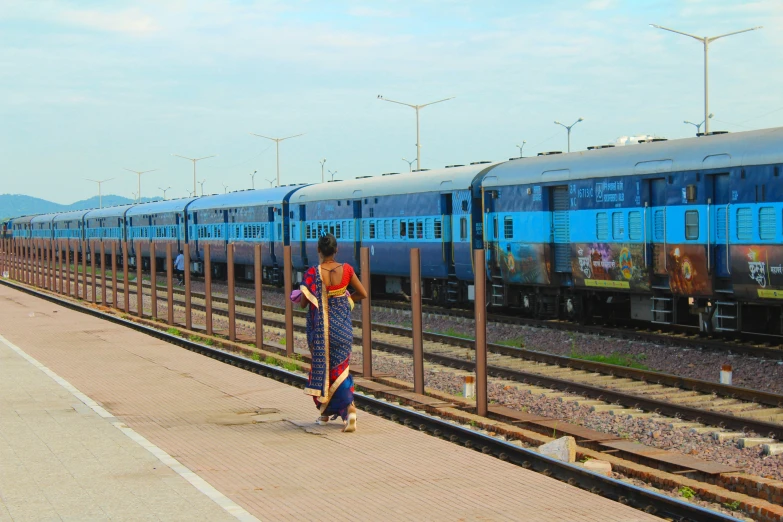 a man walks in front of the train with his foot on the rail road