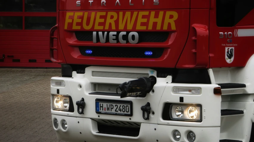 the front of a big red truck parked in front of a building