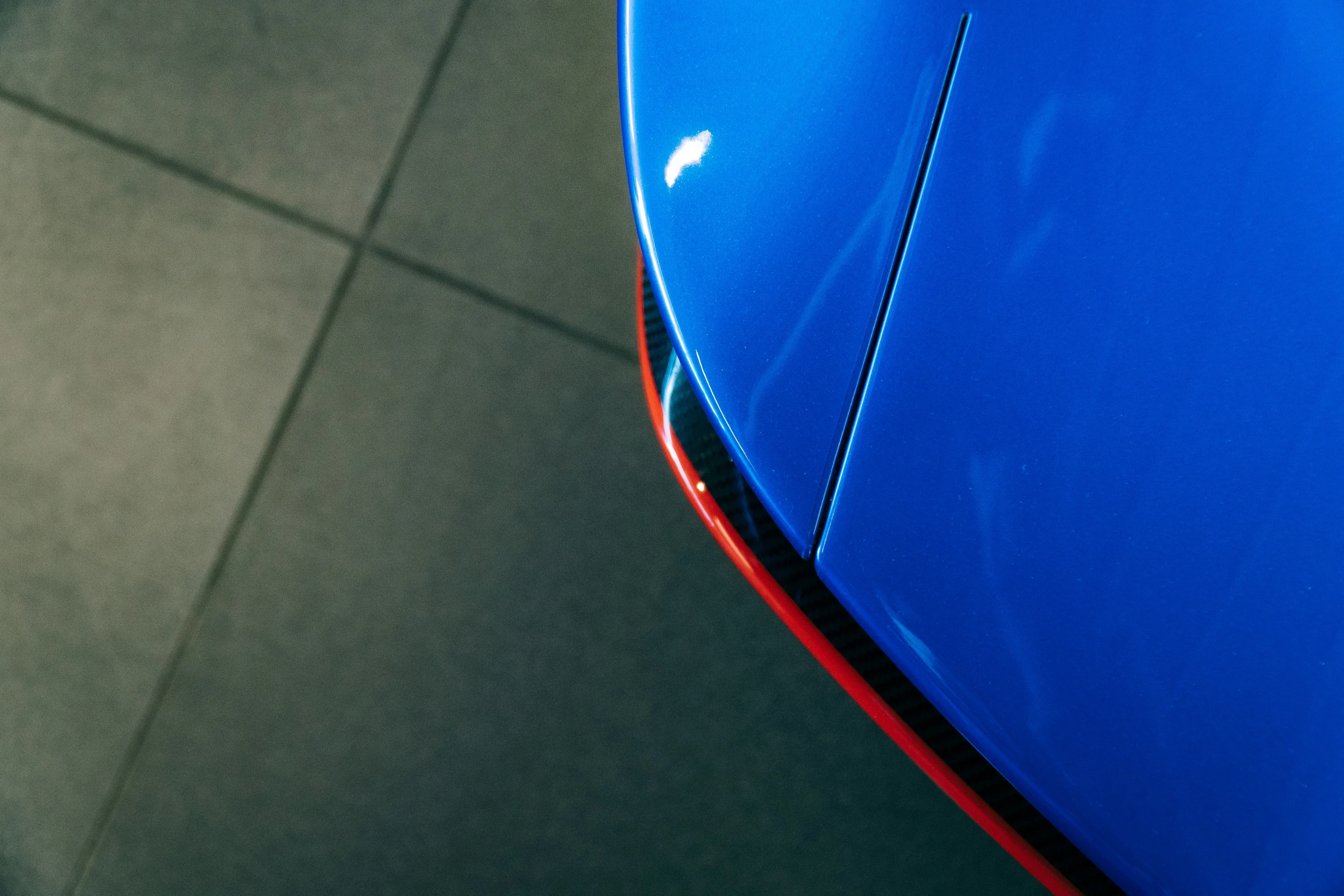 the hood of a blue sports car looking down