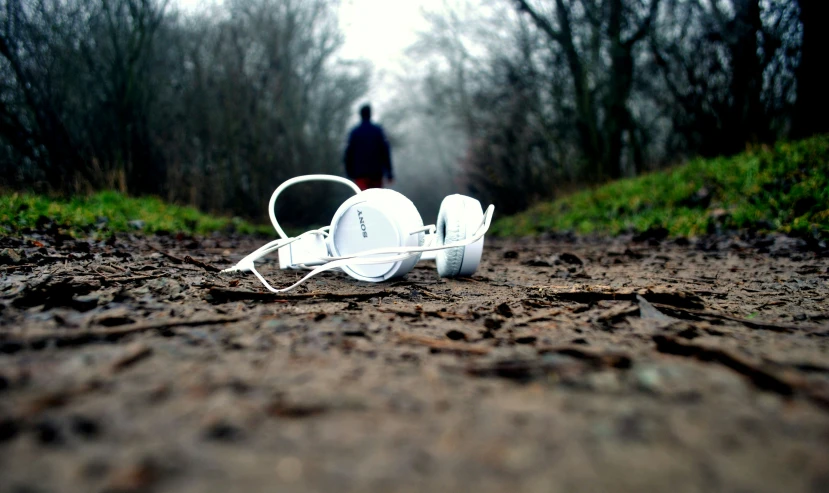 white headphones on the ground in front of a man