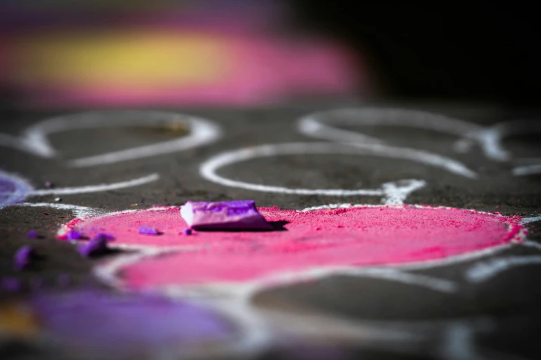 a chalk and colored paint sit on a sidewalk