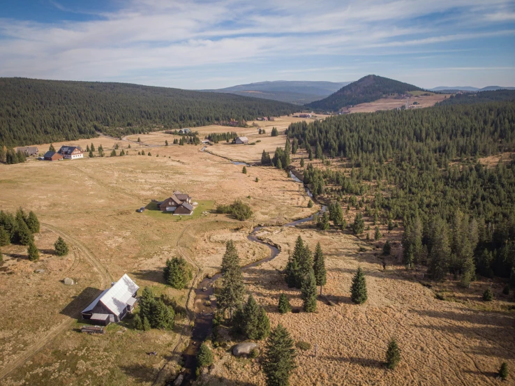 an aerial view of a small cabin sitting in the middle of trees