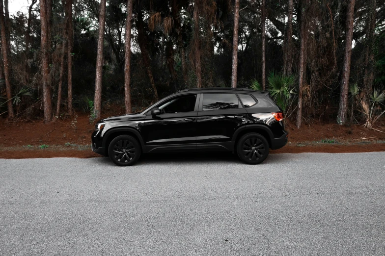 the black suv is parked on a quiet street