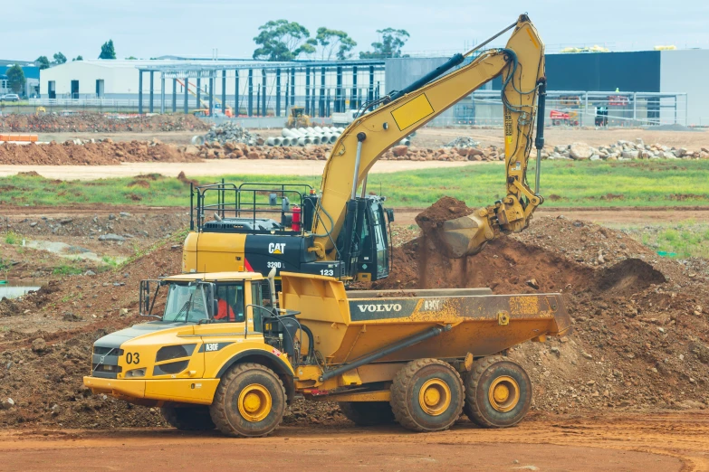 large yellow heavy truck full of dirt on street