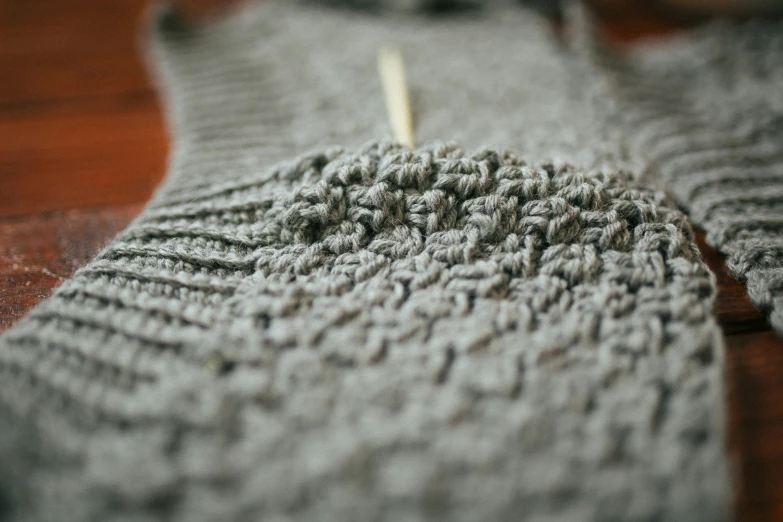 a close up of a knitted item on a wooden table