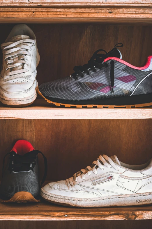 four sneakers are sitting in the wooden shelves