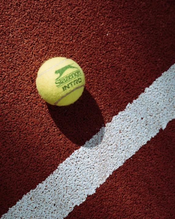 a tennis ball sitting on a red court