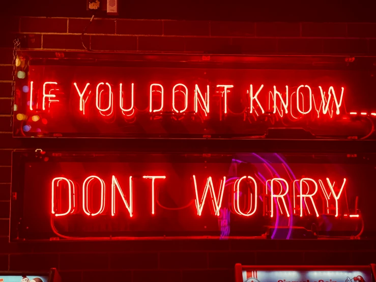 a red neon sign with words written in the middle