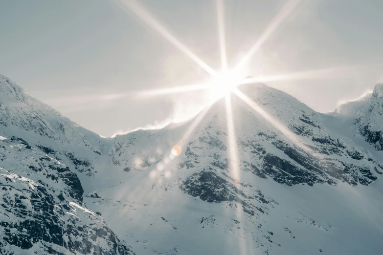 the sun is shining brightly over snowy mountaintops