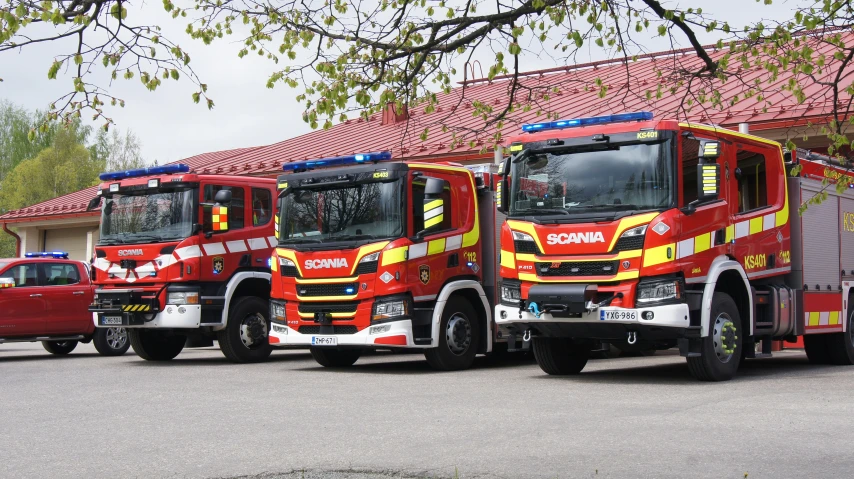 four fire trucks are lined up in front of a house