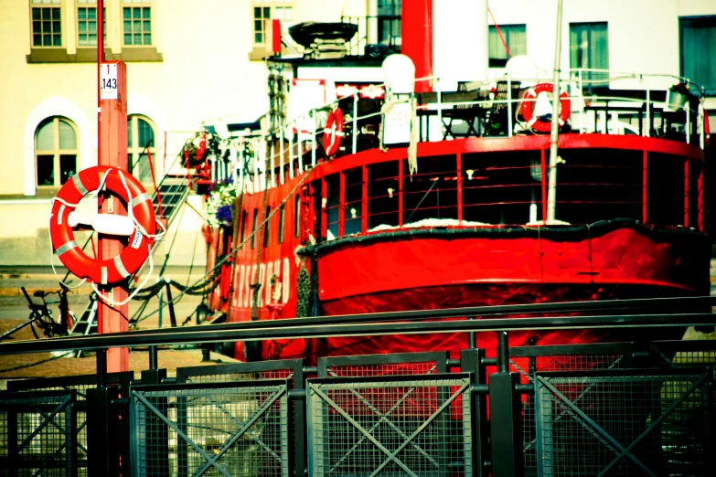 a red boat in a marina and some other buildings