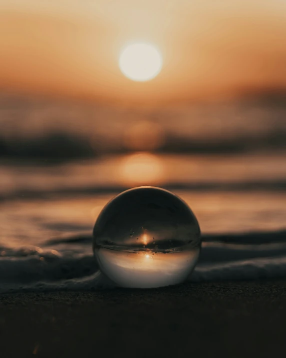 an empty water ball lying on top of the sand