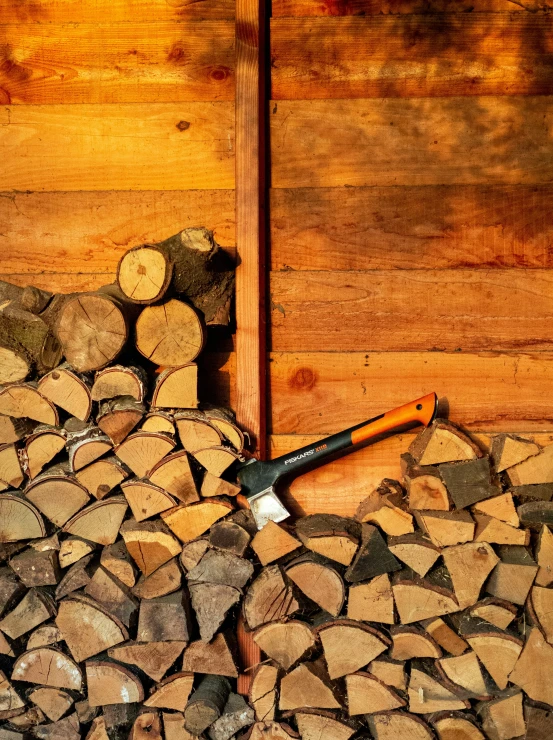 firewood stacked up with a tool on top