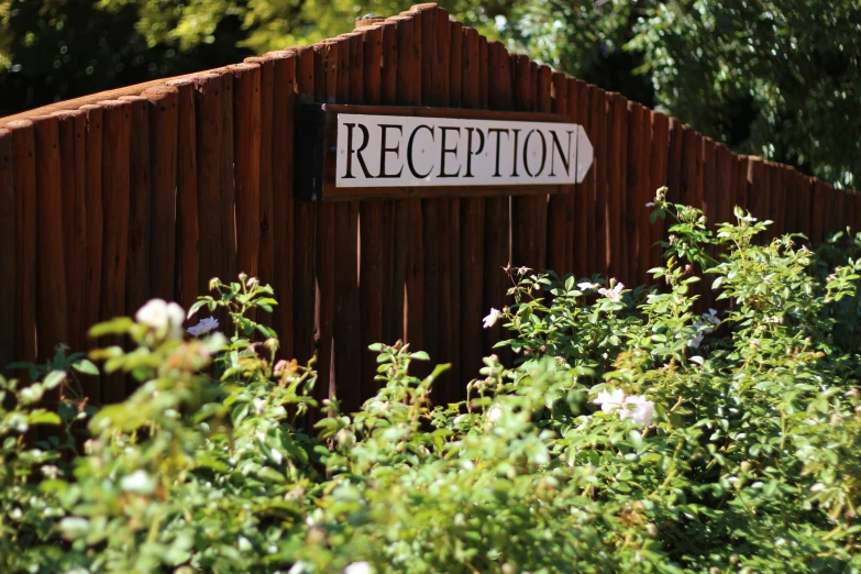 a wooden fence with a sign reading reception