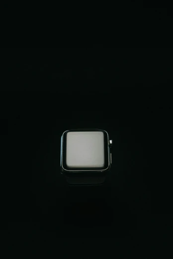 a small silver square object with a black background