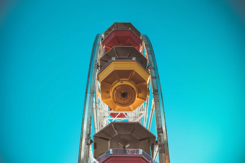 ferris wheel against a blue sky with its light