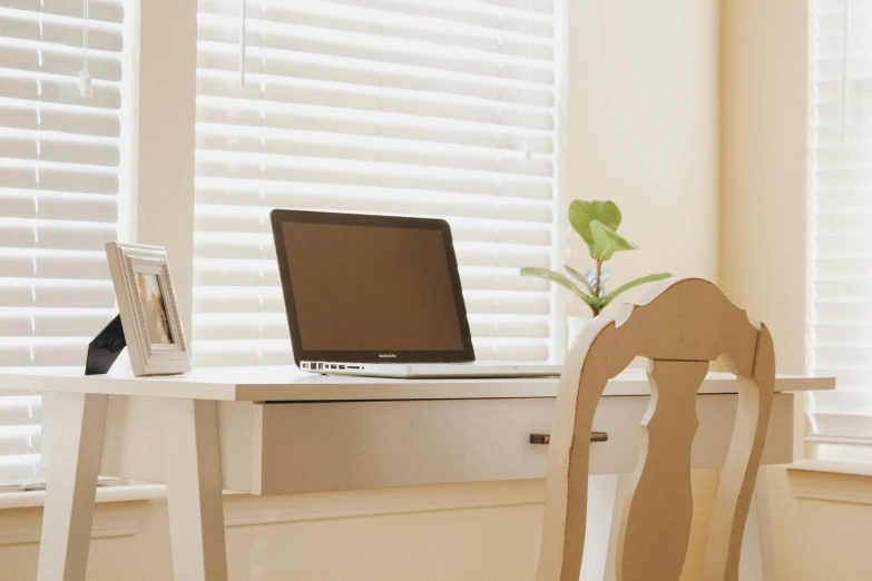 a laptop computer on top of a white desk