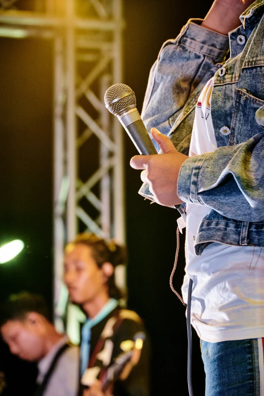 two people holding microphones while standing on a stage