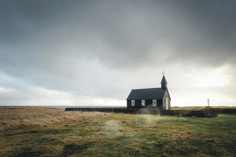 an old church stands in a grassy field