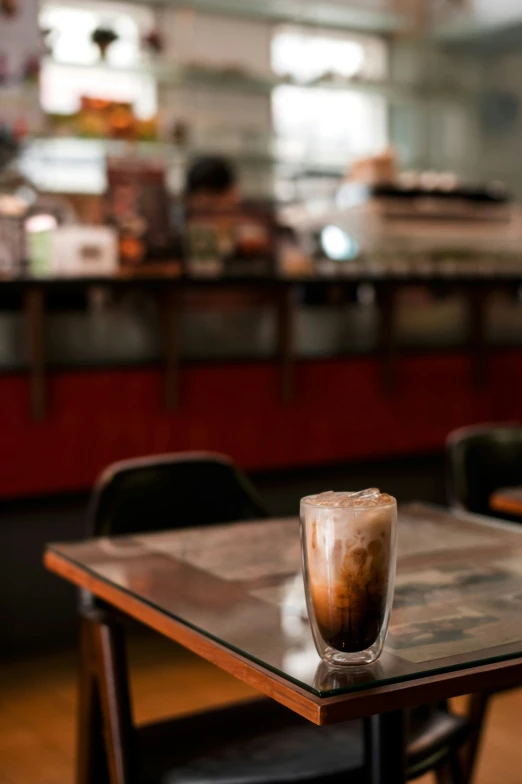 a drink sits on a table in a large restaurant