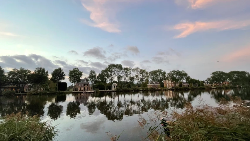 a body of water surrounded by trees and sky