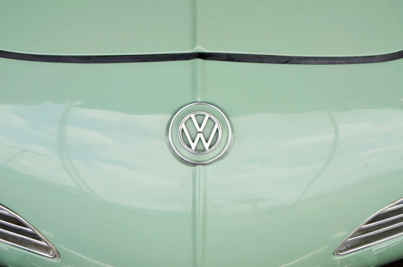 a volkswagen emblem with chrome on a pale green car