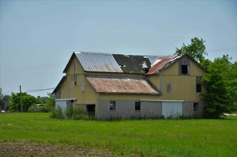 an old yellow building is in a field