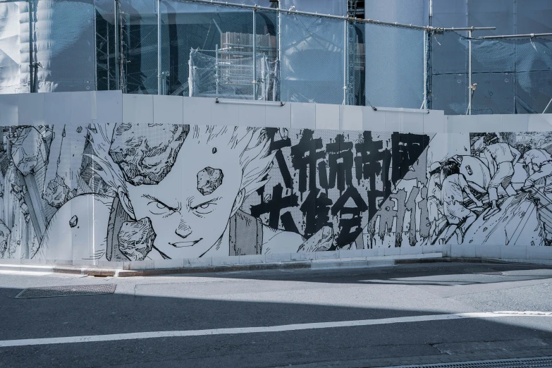 a fence surrounding a wall with some graffiti on it